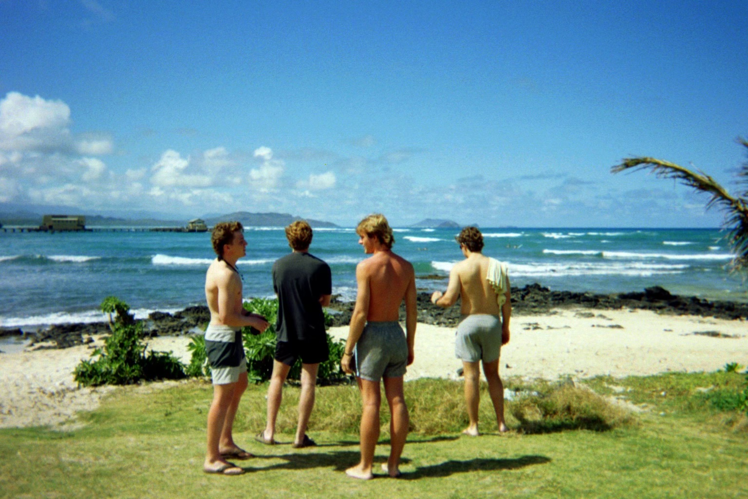 Friends standing together beside the ocean in Hawaii.